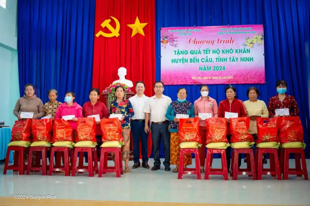 Ông Nguyễn Lê Chơn Tâm (bên trái) và đại diện lãnh đạo huyện Bến Cầu đang trao những phần quà cho các hộ khó khăn. 