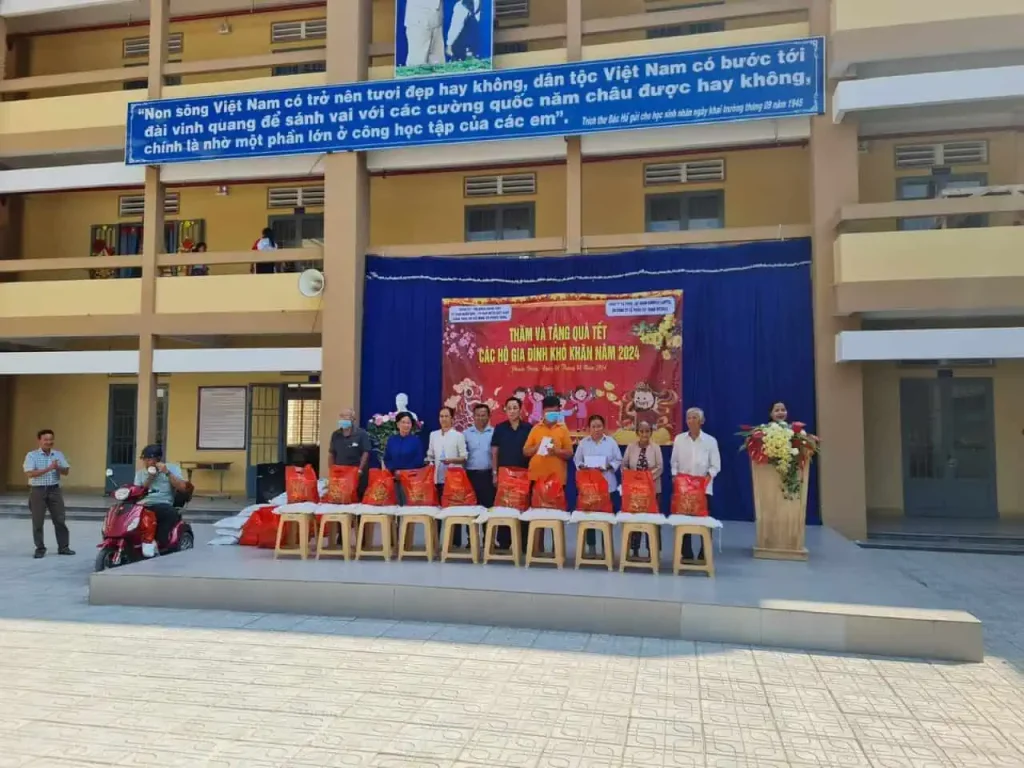 Ông Lê Văn Hóa- đại diện đoàn Cảng Sài Gòn (áo sậm ở giữa) trao quà cho những hộ dân có khó khăn tại trường Tiểu học Nguyễn Thị Bé - huyện Gò Dầu, tỉnh Tây Ninh.